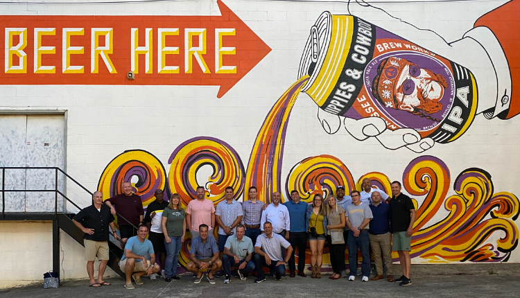 Group of people in front of a colorful beer mural
