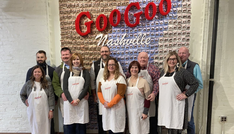 group of people in front of the Goo Goo Clusters restaurant sign in Nashville