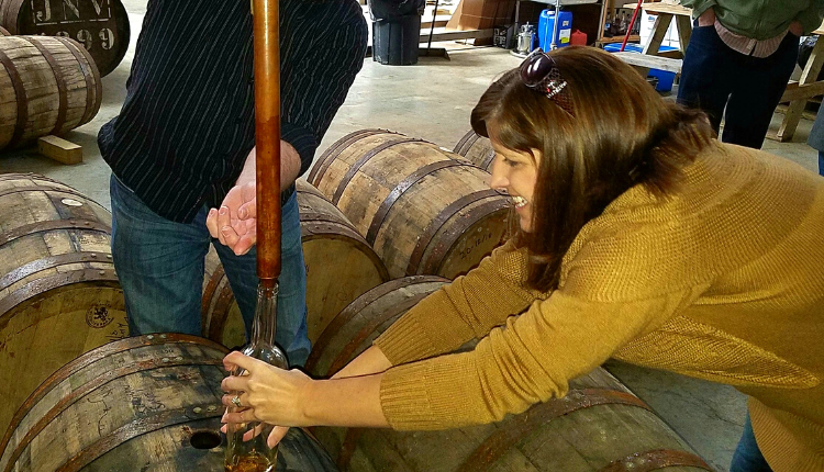 woman thieving bourbon straight from the barrel during barrel select experience