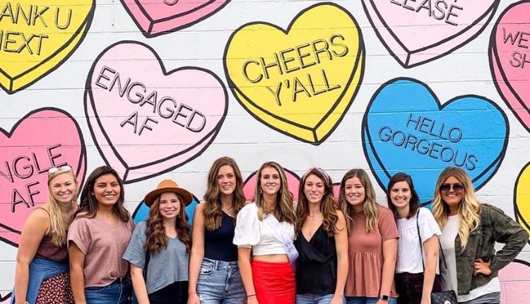 group of girls standing in front of Nashville's heart mural on a murals tour