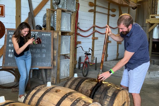 man thieving bourbon straight from the barrel on bourbon tour