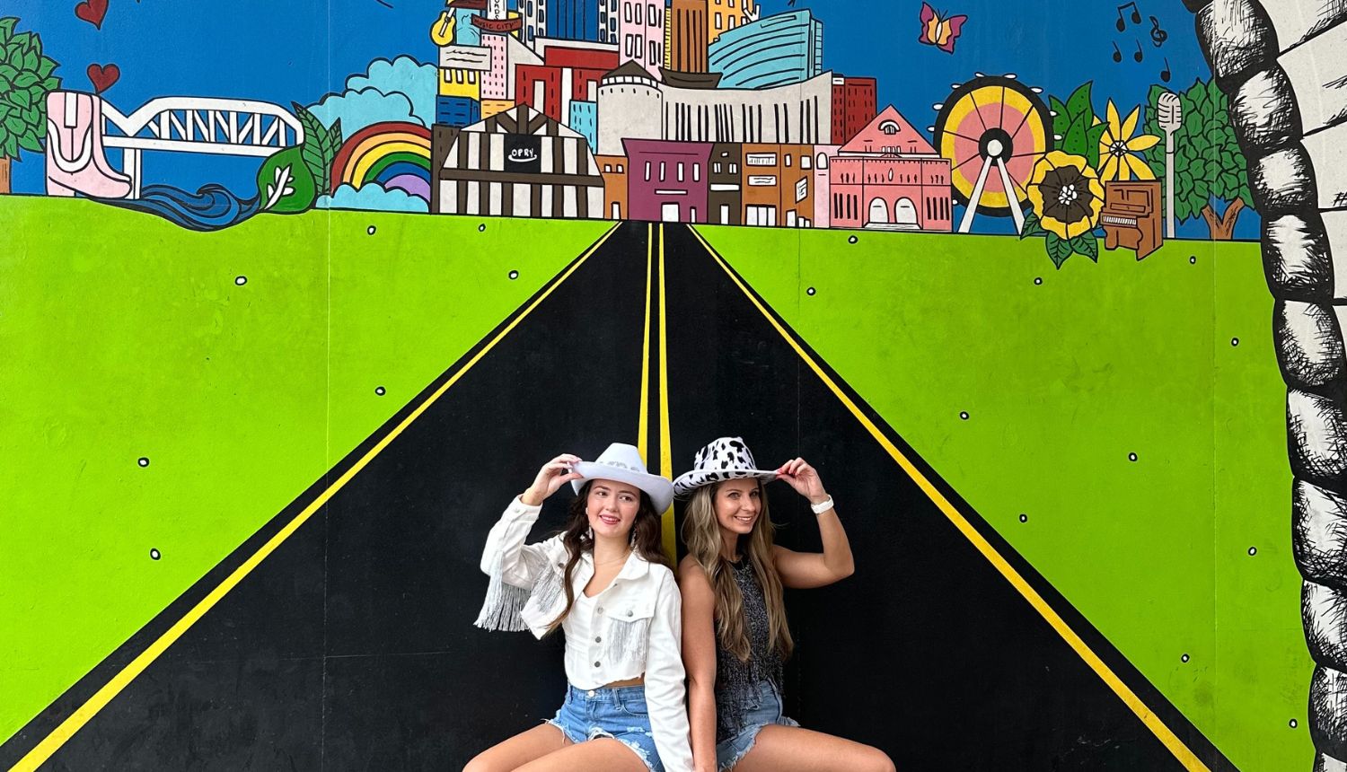 girls posing in front of Nashville Travel Mural on tour